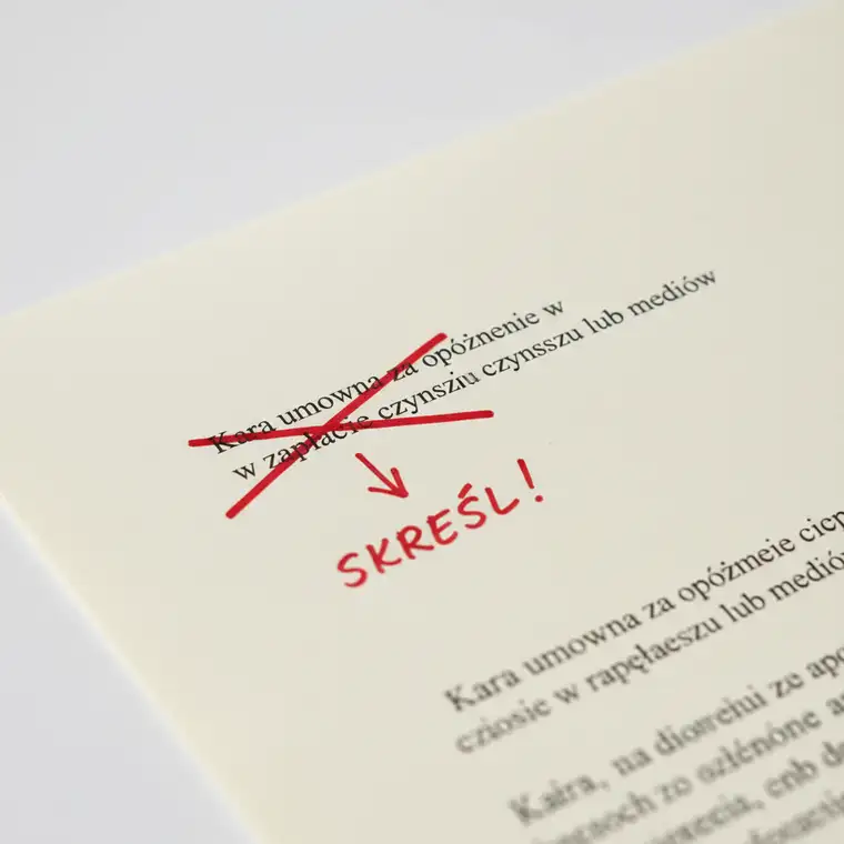 Student podpisujący umowę najmu okazjonalnego pokoju, analizujący zapisy o karze umownej, aby skreślić ryzykowne klauzule i uniknąć naciągania